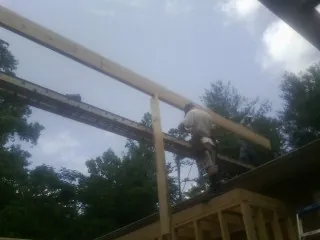 Carpenter setting a ridge beam over a new addition frame — Ice Dam Removal by Roofing Brothers in Bowerston