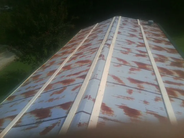 Rusted metal roof panels with new wood purlins before replacement — Storm Damage Roof Repair in Bowerston by Roofing Brothers