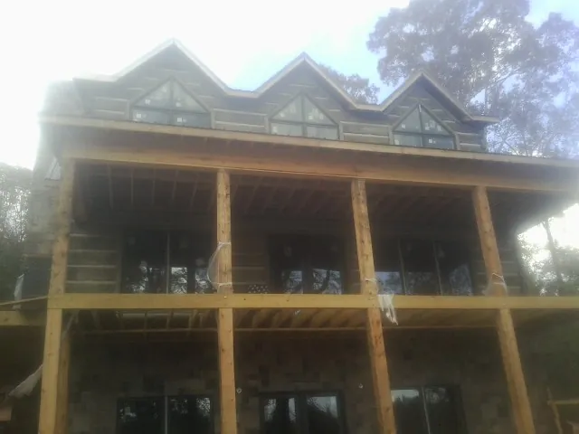 Dormers and porch framing on a large log home under construction — Roof Coating work by our crew in Bowerston