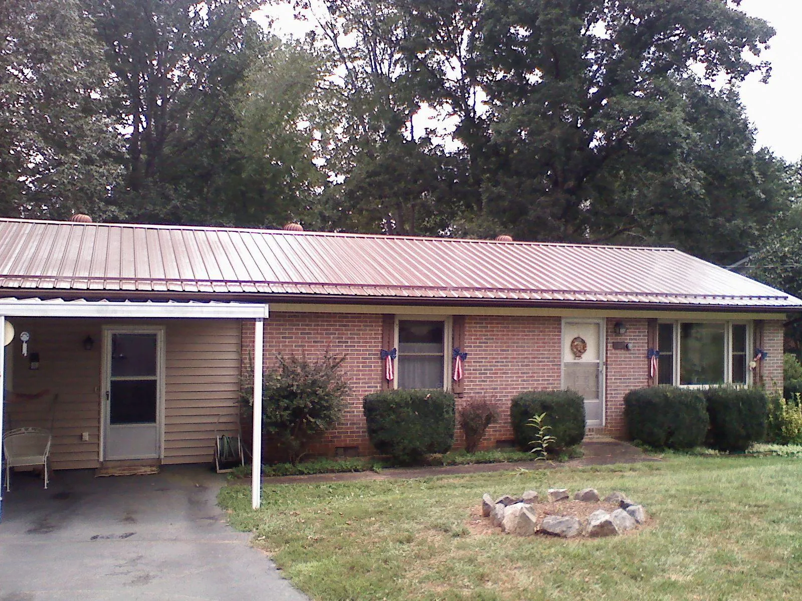 Bronze metal roof and carport on a brick ranch home — Roof Repair work by our crew in Bowerston